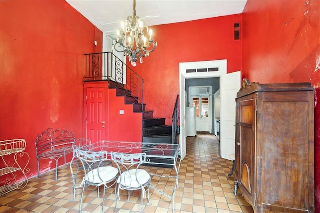 dining area featuring a chandelier, tile patterned floors, and lofted ceiling