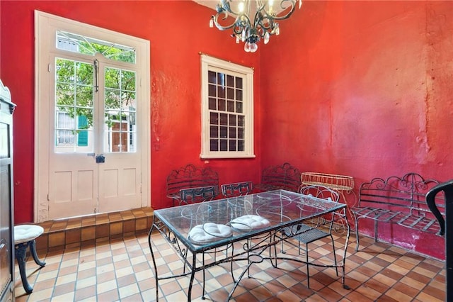 dining area with tile patterned flooring and an inviting chandelier