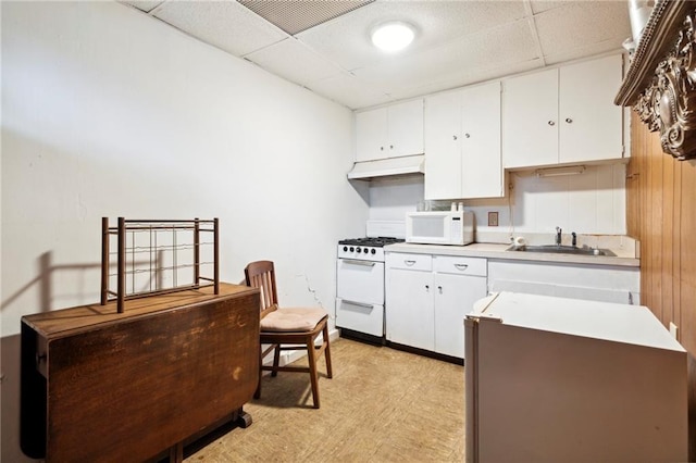 kitchen with sink, white cabinets, a drop ceiling, and white appliances