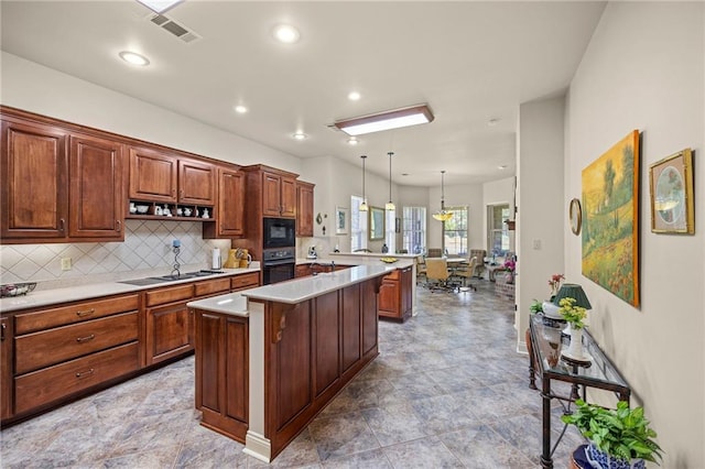 kitchen featuring pendant lighting, black appliances, tasteful backsplash, a kitchen island, and a kitchen bar