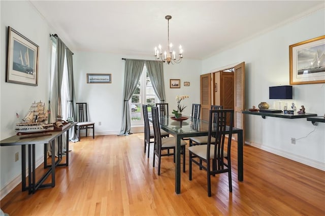 dining room with light hardwood / wood-style floors and a notable chandelier