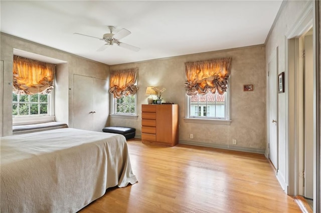 bedroom with multiple windows, light wood-type flooring, and ceiling fan