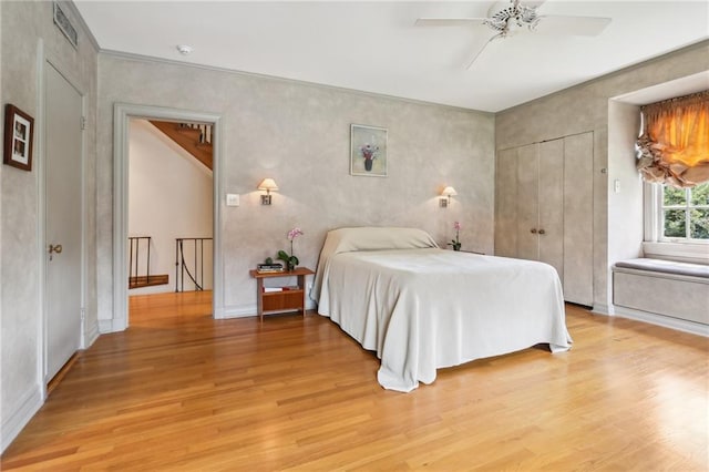 bedroom featuring ceiling fan, a closet, and light wood-type flooring