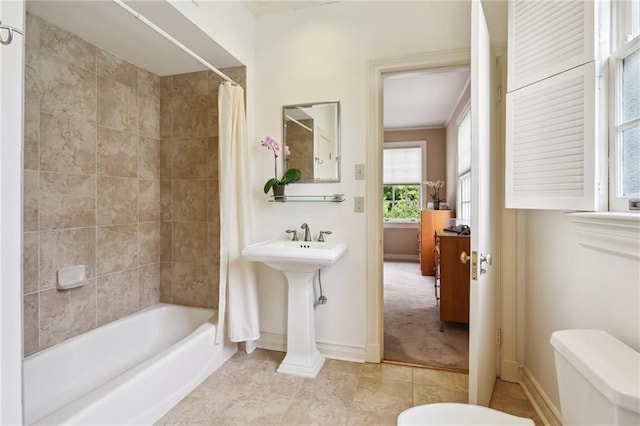 bathroom featuring shower / bathtub combination with curtain and toilet