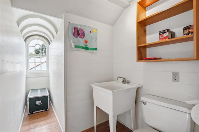 bathroom with hardwood / wood-style flooring, toilet, and lofted ceiling