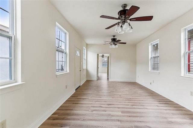 unfurnished room featuring light wood-type flooring, plenty of natural light, and ceiling fan