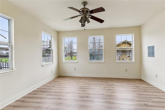 unfurnished room with electric panel, light hardwood / wood-style floors, plenty of natural light, and ceiling fan