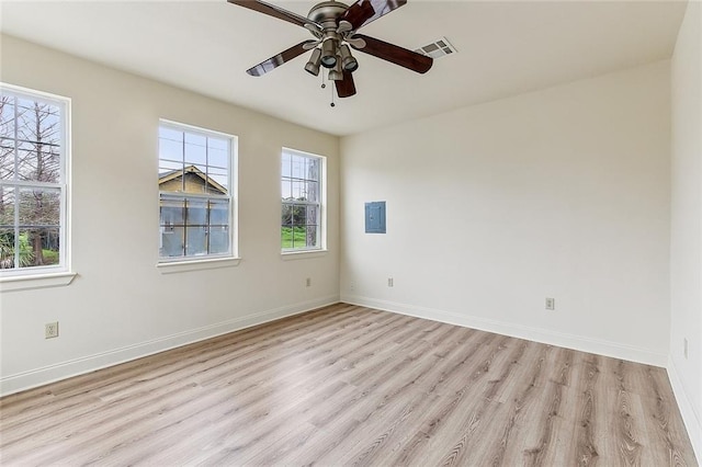 empty room featuring electric panel, ceiling fan, and light wood-type flooring