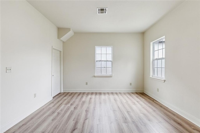 empty room featuring a wealth of natural light and light hardwood / wood-style floors