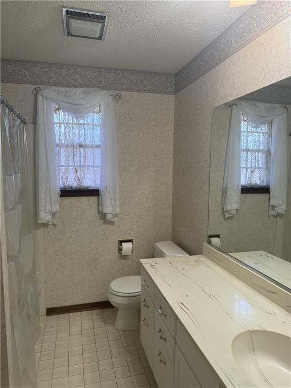 bathroom featuring tile patterned floors, vanity, toilet, and a textured ceiling