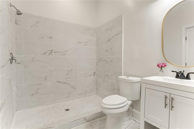 bathroom with vanity, toilet, and a tile shower