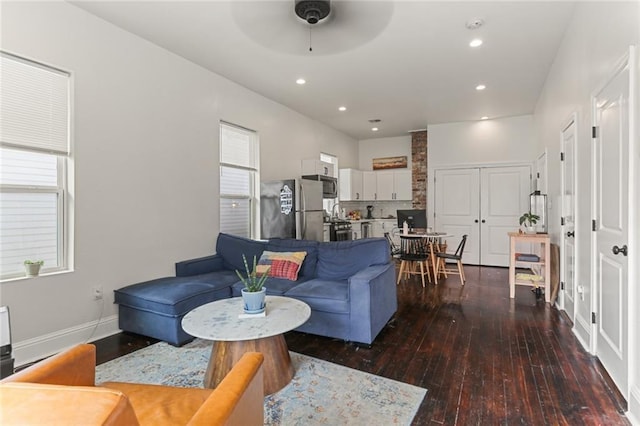 living room featuring ceiling fan and dark wood-type flooring