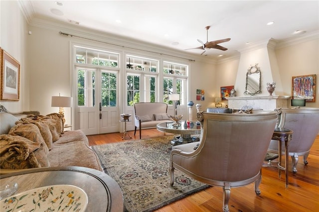 living room with visible vents, a ceiling fan, wood finished floors, recessed lighting, and crown molding