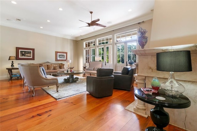 living room with hardwood / wood-style floors, crown molding, recessed lighting, and baseboards