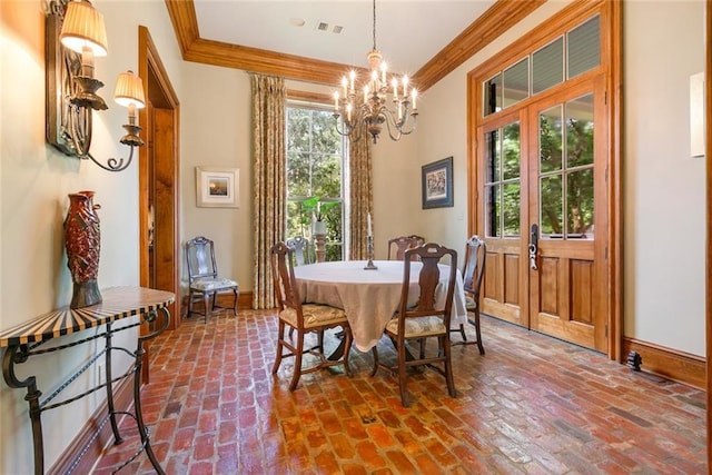 dining space featuring visible vents, crown molding, and brick floor