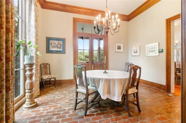 dining room with a notable chandelier, french doors, crown molding, brick floor, and baseboards