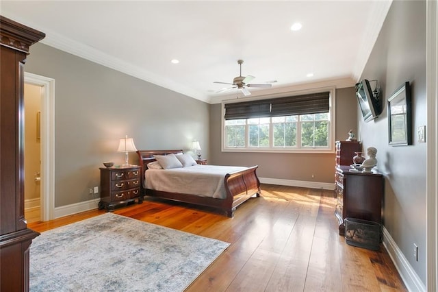 bedroom featuring light wood-type flooring, baseboards, and crown molding