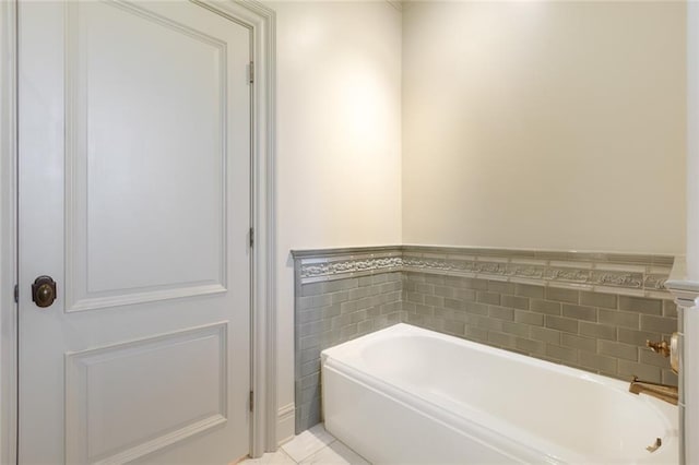 bathroom featuring a wainscoted wall, a garden tub, tile walls, and tile patterned flooring