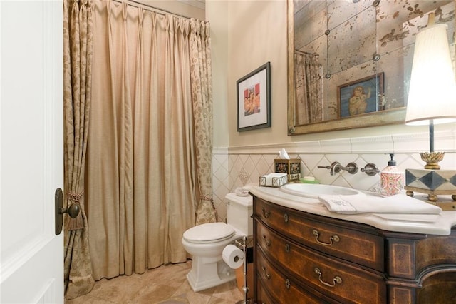 full bath featuring a wainscoted wall, toilet, vanity, a shower with curtain, and tile walls