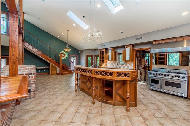 500 W Willow St, Ponchatoula, LA 70454 - kitchen with pendant lighting, backsplash, range with two ovens, a skylight, and light tile patterned flooring