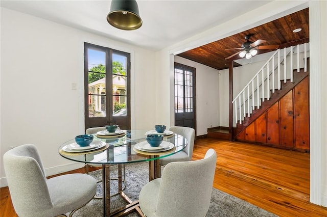 dining space with ceiling fan, hardwood / wood-style flooring, beam ceiling, and wooden ceiling