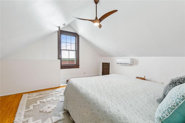 bedroom featuring wood-type flooring, vaulted ceiling, ceiling fan, and a wall mounted AC