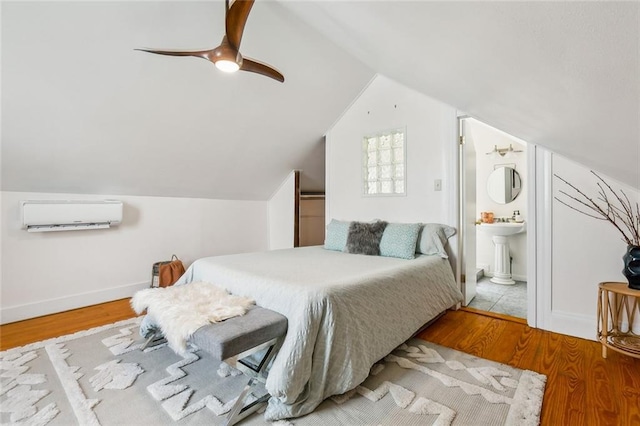 bedroom with ceiling fan, light hardwood / wood-style flooring, a wall mounted air conditioner, and lofted ceiling