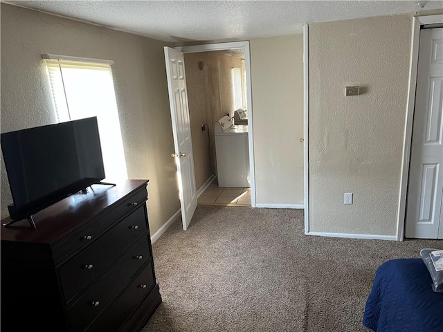 unfurnished bedroom featuring washer / clothes dryer, a textured ceiling, and tile patterned floors