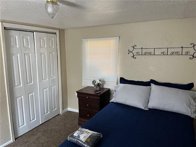 bedroom with a closet, a textured ceiling, ceiling fan, and dark carpet