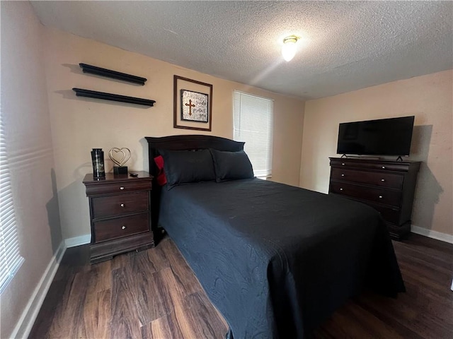 bedroom with dark wood-type flooring and a textured ceiling