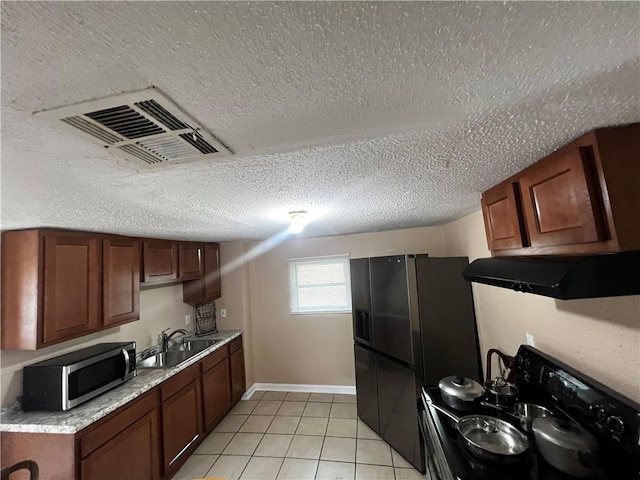 kitchen with sink, black appliances, a textured ceiling, and light tile patterned floors