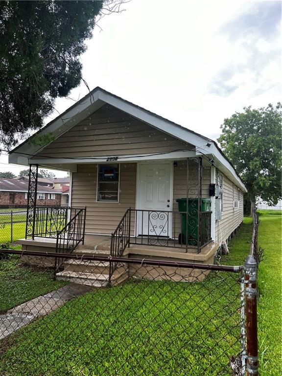 bungalow featuring covered porch and a front lawn