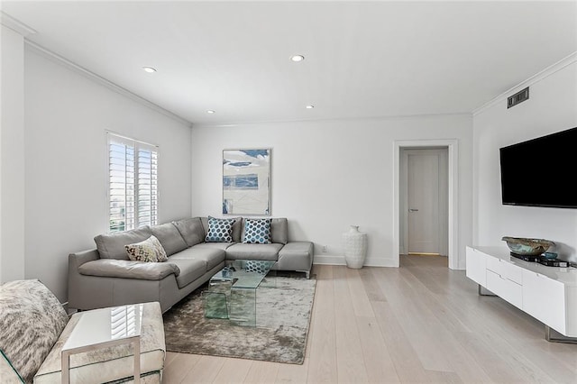 living room featuring light wood-type flooring and ornamental molding