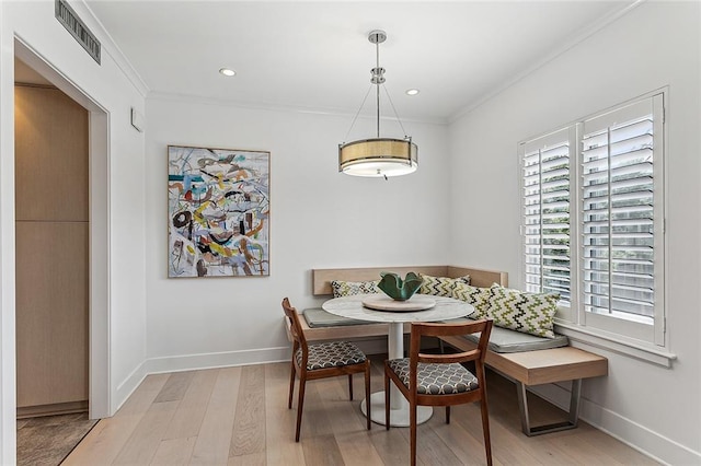 dining area featuring light hardwood / wood-style floors and ornamental molding