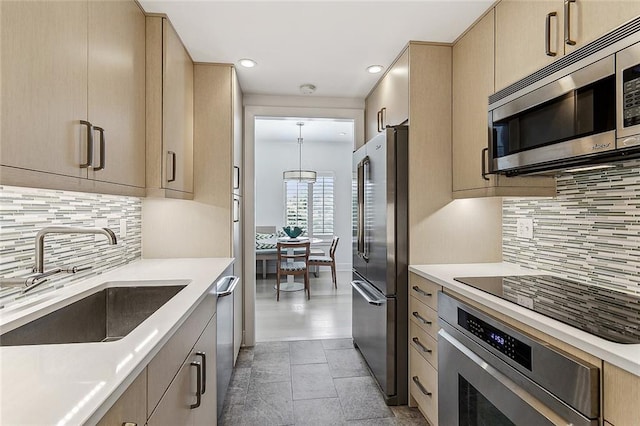 kitchen featuring appliances with stainless steel finishes, light tile patterned flooring, decorative backsplash, and sink