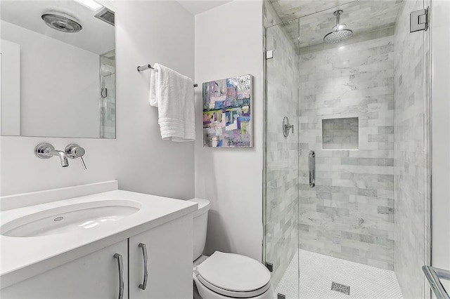 bathroom with a shower with shower door, vanity, and toilet