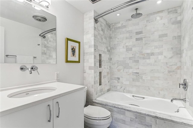 full bathroom with vanity, toilet, tiled shower / bath, and visible vents