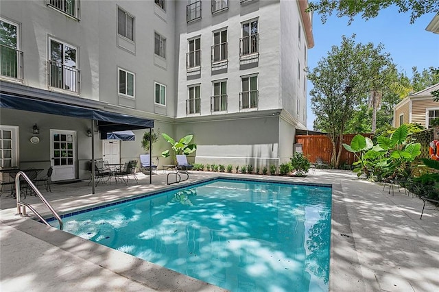 view of swimming pool with a patio and fence