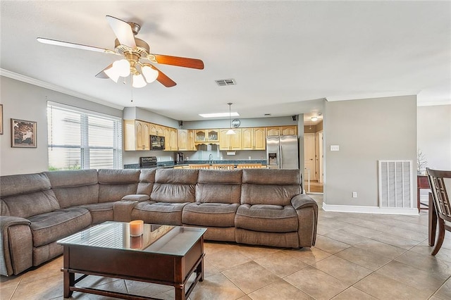 tiled living room featuring ceiling fan, sink, and ornamental molding