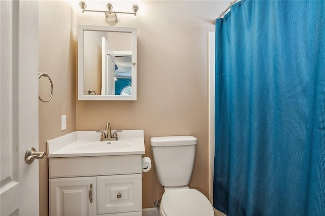 bathroom featuring a shower with shower curtain, vanity, and toilet