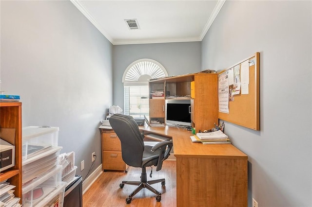 home office with light hardwood / wood-style floors and ornamental molding