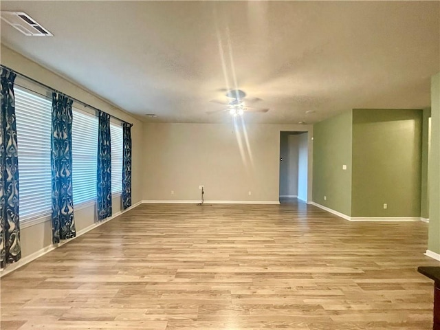 empty room with light hardwood / wood-style floors and ceiling fan