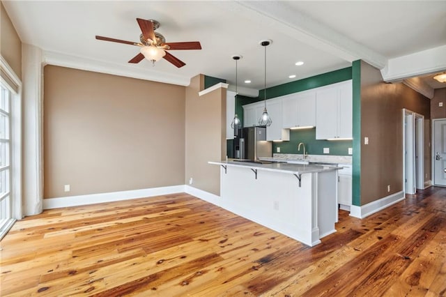 333 Julia St Unit 519, New Orleans, LA 70130 - kitchen with light countertops, a kitchen bar, stainless steel fridge with ice dispenser, a sink, and ceiling fan