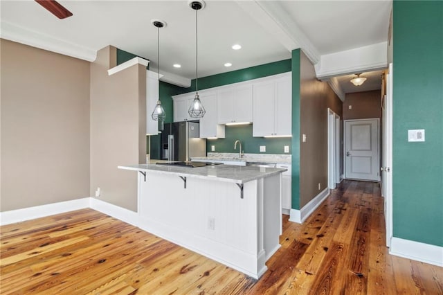 333 Julia St Unit 519, New Orleans, LA 70130 - kitchen with white cabinets, a peninsula, light wood finished floors, stainless steel refrigerator with ice dispenser, and a kitchen breakfast bar