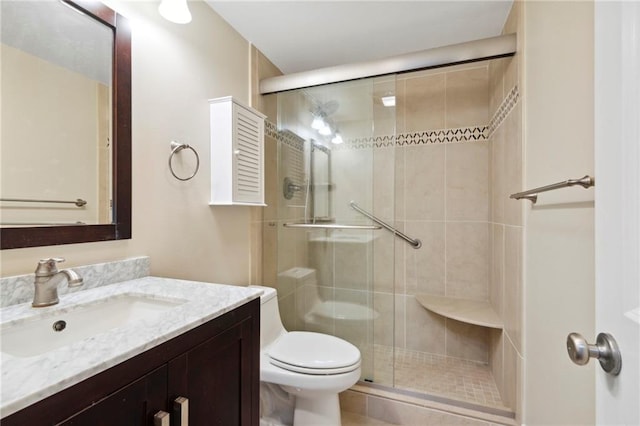 bathroom with an enclosed shower, vanity, and toilet