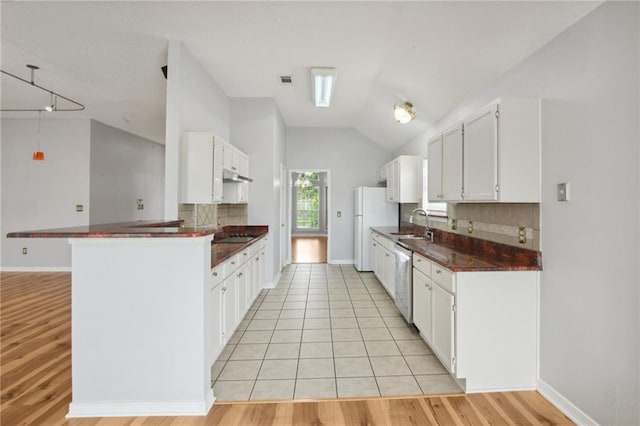 kitchen featuring white cabinets, vaulted ceiling, backsplash, and kitchen peninsula