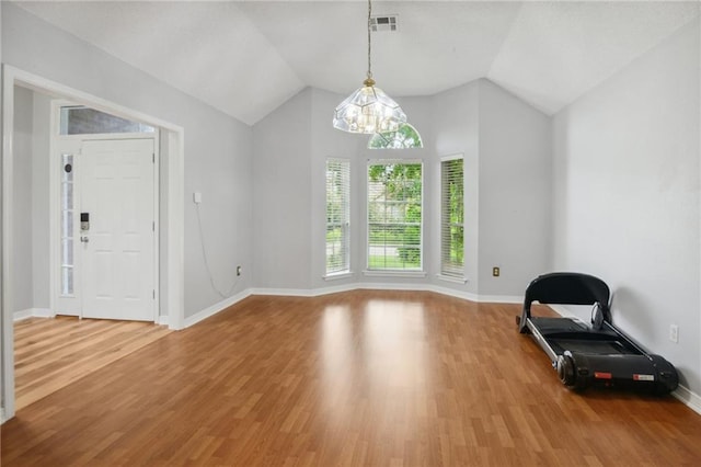 interior space featuring lofted ceiling, hardwood / wood-style flooring, and a notable chandelier