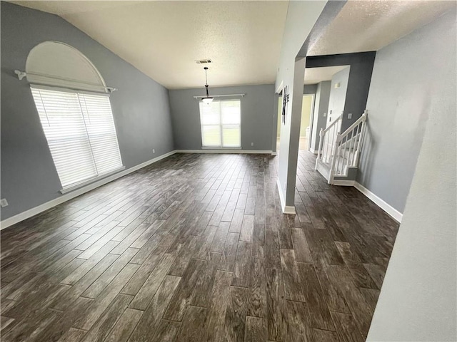 interior space featuring vaulted ceiling, dark hardwood / wood-style flooring, and a textured ceiling