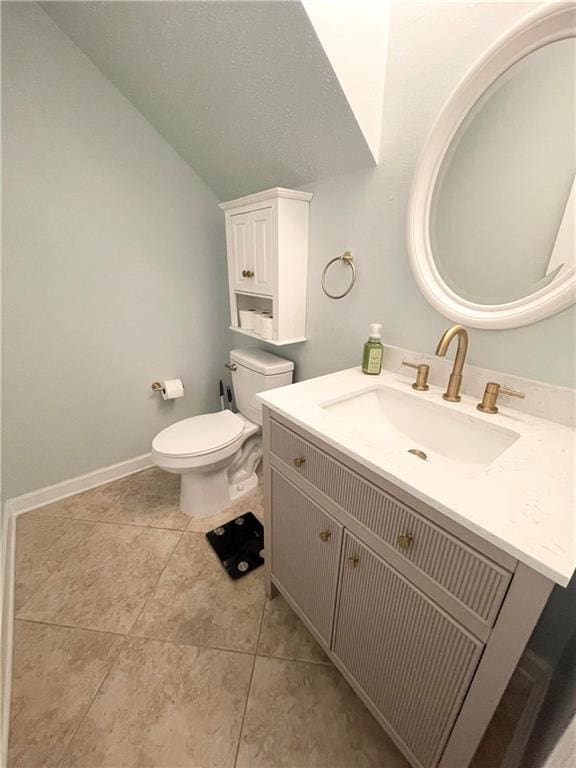 bathroom with vaulted ceiling, vanity, tile patterned floors, and toilet