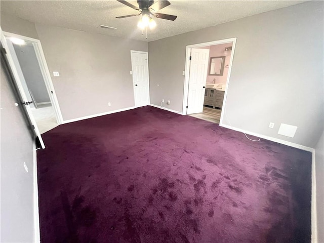 carpeted spare room with a textured ceiling and ceiling fan